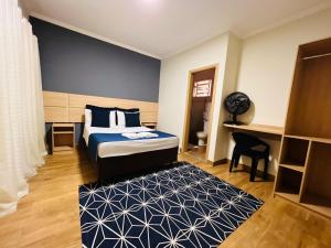 a bedroom with a bed and a black and white rug at HOTEL ARLEN 2 in Pouso Alegre