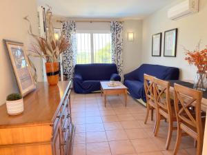 a living room with a blue couch and a table at Villas Monte Jávea - BTB in Jávea