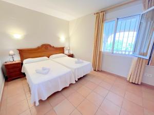a bedroom with two beds and a large window at Villas Monte Jávea - BTB in Jávea