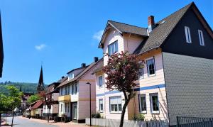 a row of houses on a street with a church at HIRSCH FeWo Brocken - Parkplatz - Zentral in Bad Harzburg