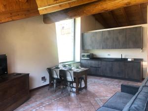 a dining room with a table and a couch at TROIS COURONNES - GRANDE ROCHERE Appartamento di Charme a La Salle Valle d'Aosta in La Salle