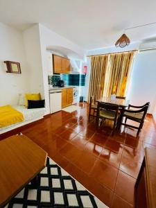 a living room with a table and a kitchen at Resort Albufeira T1, Praia da Oura in Albufeira