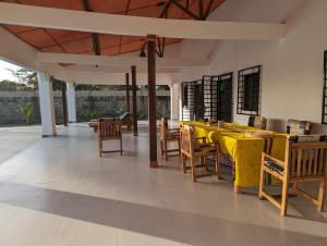 een eetkamer met een gele tafel en stoelen bij Flower Garden House in Sanyang