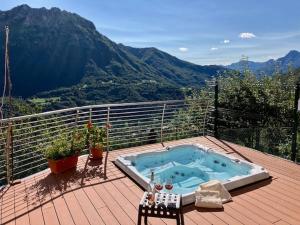 a jacuzzi tub on a deck with mountains in the background at Da Gigi Alpine Rooms in Crandola Valsassina