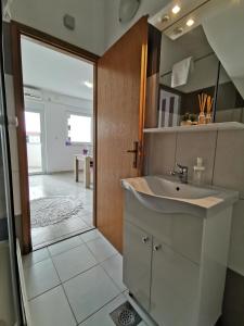 a bathroom with a sink and a sliding glass door at Apartments Riva Povljana in Povljana +208 photos
