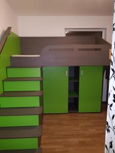 a bedroom with a bunk bed with green walls at Casa Geo in Vadu
