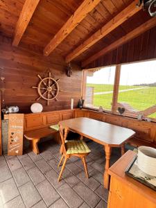 een eetkamer met een houten tafel in een hut bij Ferienhaus Praschberg in Niederndorferberg