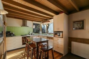 a kitchen with white cabinets and a table and chairs at Tambo in Dinner Plain