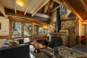 a living room with a stone fireplace in a house at Tambo in Dinner Plain