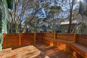a wooden fence on a deck with trees in the background at Tambo in Dinner Plain