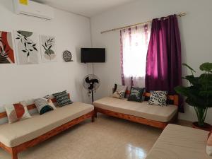 ein Wohnzimmer mit zwei Sofas und einem Fenster in der Unterkunft Sawsen Ghar el melh in Ghār al Milḩ