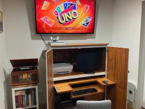 a desk with a tv and a computer on a wall at Beach Holiday Home-Close to Airport-3 Bed & 2 Bath in Lauderdale