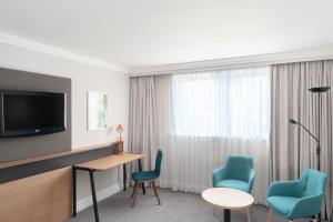 a hotel room with a desk and two chairs at Holiday Inn Hemel Hempstead M1, Jct. 8, an IHG Hotel in Hemel Hempstead