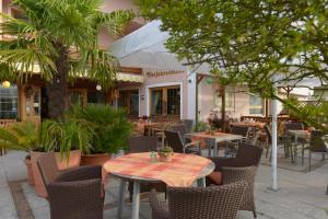 an outdoor patio with tables and chairs and plants at Hotel Vierjahreszeiten in Breitengüßbach