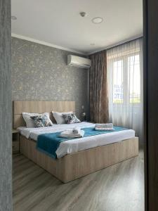 a bedroom with a large bed with blue sheets at Tbilisi Center Hotel in Tbilisi City