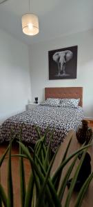 a bedroom with a bed with a plant in front of it at Maison charmante avec patio ! in Bourges