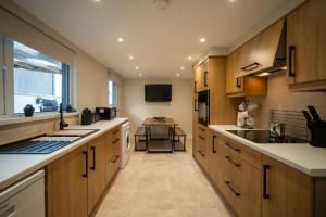 a large kitchen with wooden cabinets and a table at Pullindoos Self-Catering in Beltoy