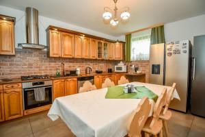 una cocina con una mesa y un refrigerador en Za górami Za lasami Zakopane, en Zakopane 148 fotos más