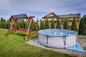 Un jacuzzi y un columpio en un patio. en Za górami Za lasami Zakopane, en Zakopane