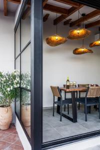 a dining room with a table and chairs and lights at SeaScape Boutique Villa in Achlia +45 photos