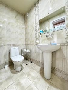 a bathroom with a white toilet and a sink at Tbilisi Center Hotel in Tbilisi City