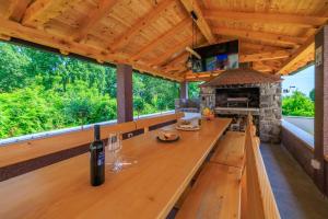 an outdoor kitchen with a table with a bottle of wine at Apartmani Vesna in Opric