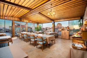 a restaurant with tables and chairs and large windows at Woox Cappadocia in Uçhisar