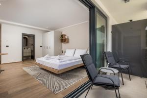 a bedroom with a bed and two chairs at Belinda apartments with balcony in Opatija