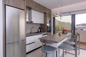 a kitchen with a stainless steel refrigerator and stools at Plakias Galaxy Villas in Plakias