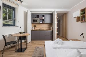 a room with a bed and a table and a kitchen at Belinda apartments with balcony in Opatija