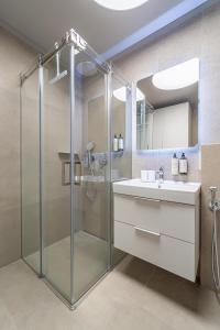 Un baño con ducha de cristal y lavabo. en cohost I New Apt w-Balcony I Air Condition I Free Parking & Netflix I By Botanical Park, en Kaunas