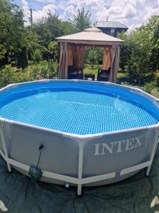 a large swimming pool with a gazebo at Casa Hariton in Drăguş