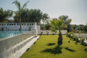 a garden with a pool and some birds on the grass at Bliss Villas in Rethymno Town