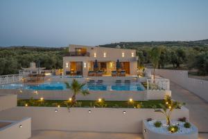 a villa with a swimming pool at night at Bliss Villas in Rethymno Town