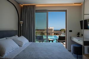 a bedroom with a bed and a balcony with a pool at Bliss Villas in Rethymno Town