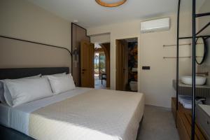 a bedroom with a white bed and a bathroom at Bliss Villas in Rethymno Town