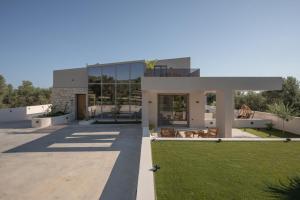 a modern house with a lawn in front of it at Bliss Villas in Rethymno Town