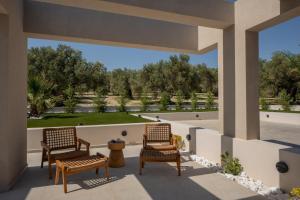 a patio with two chairs and a view of a park at Bliss Villas in Rethymno Town