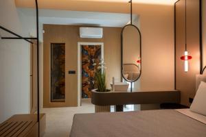 a bedroom with a bed with a mirror and a sink at Bliss Villas in Rethymno Town