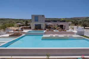 a villa with a swimming pool and a house at Bliss Villas in Rethymno Town