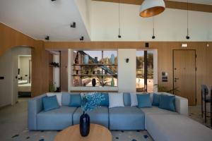 a living room with a blue couch and a table at Bliss Villas in Rethymno Town