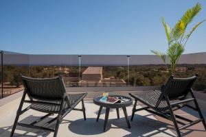 two chairs and a table on a balcony with a view at Bliss Villas in Rethymno Town