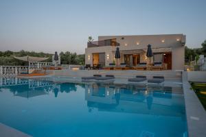 a house with a swimming pool in front of a house at Bliss Villas in Rethymno Town