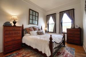 a bedroom with a bed and a dresser and windows at Historic Mountain Loft with GREAT Views in Leadville