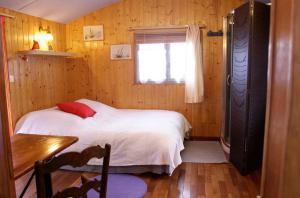 a bedroom with a bed and a table and a window at Charmante Péniche - Séjour atypique Nantes in Nantes