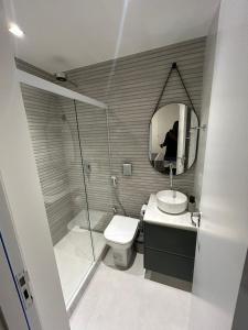ein Bad mit einer Dusche, einem WC und einem Spiegel in der Unterkunft 2Qtos, Newly Renovated, Botafogo Mall and Beach in Rio de Janeiro