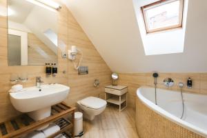 e bagno con lavabo, servizi igienici e vasca. di Hotel Latrán a Cesky Krumlov