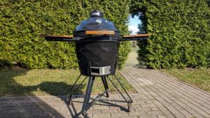 a grill on a stand on a sidewalk at Vila Vynuogyne in Paberžė