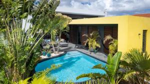 una piscina davanti a una casa con palme di Tropical Paradise at Jan Thiel with Private Pool a Jan Thiel