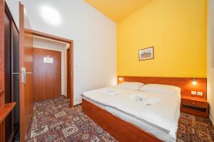 a bedroom with a bed with a yellow wall at City Central De Luxe in Prague